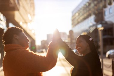 İki güzel mutlu kız arkadaş birbirlerine beşlik çakıyor.