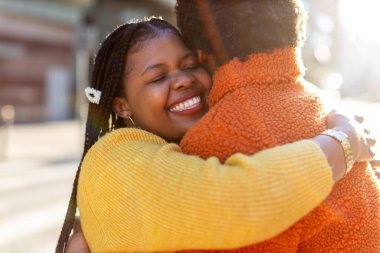İki bayan arkadaş birbirlerini selamlıyor ve sarılıyorlar.