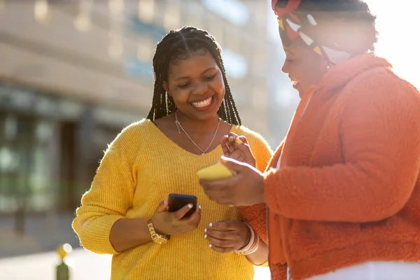 Mutlu bayan arkadaşlar şehirdeki akıllı telefonlarıyla mesaj yolluyor.