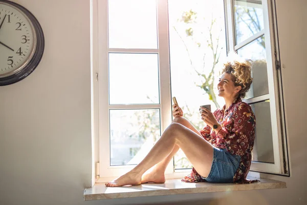 Jeune Femme Assise Sur Rebord Fenêtre Utilisant Smartphone — Photo