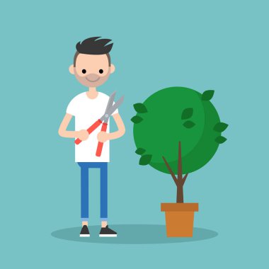 Genç adam kesme bir budayıcı ile bush / düz düzenlenebilir sakallı