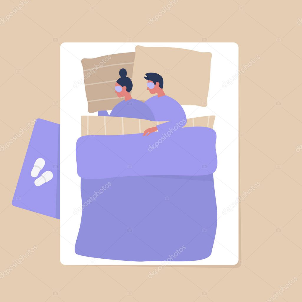 Top view of a young adult couple cuddling under the blanket in t