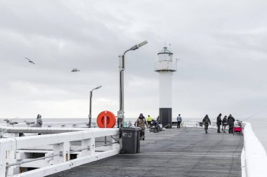 Nieuwpoort, Belgium - December 21, 2019 : Fishermen on the Westerstaketsel pier