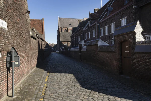 Гент, Бельгия - 22 марта 2020 года: Аллея в бегинаже Святой Елизаветы или Грут Бегейнхоф. Кирпичная стена — стоковое фото