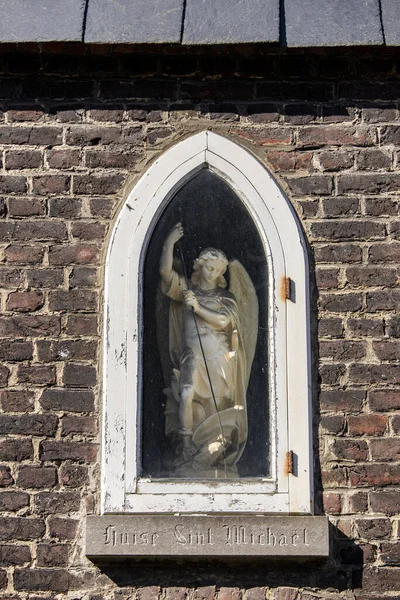 Gent, Belgien - 22. März 2020: Statue des heiligen Michael in einer Mauer im Beginenhof der heiligen Elisabeth gefunden. UNESCO-Liste. — Stockfoto