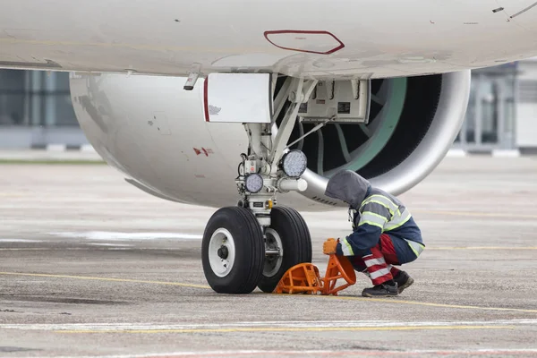 Ein Bodenkontrolleur Stellt Den Radkeil Unter Das Rad — Stockfoto