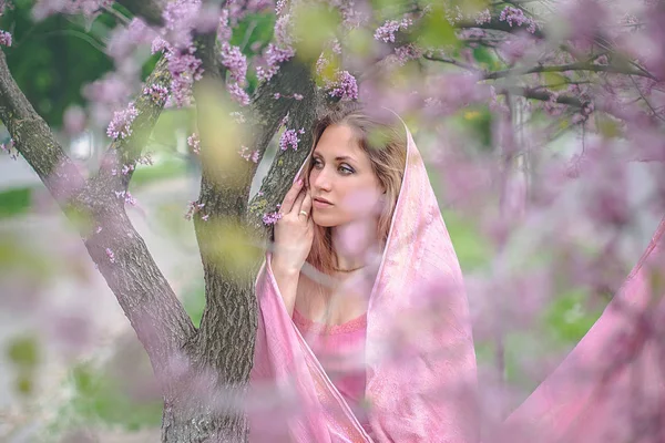 盛开的春天到处散发出芬芳 一个穿着斗篷的可爱女孩站在树下 — 图库照片