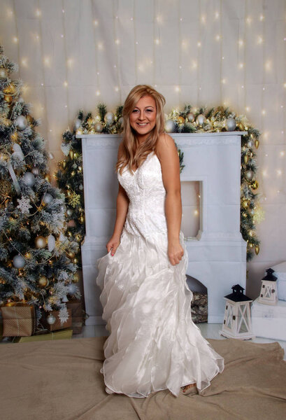 Blonde woman with christmas background, white dress