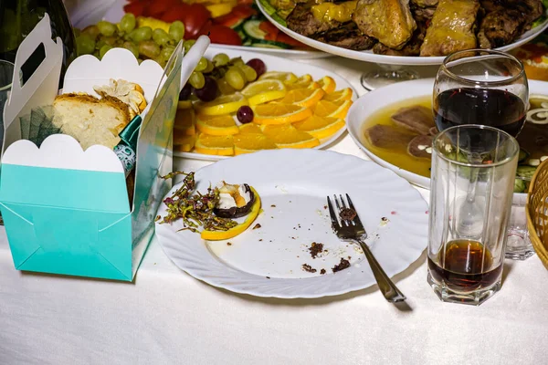 Den överblivna maten och smutsiga rätter på restaurangbordet. Skrot som blivit över efter festen. — Stockfoto