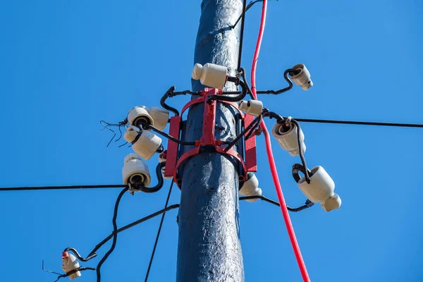 Isolateurs en porcelaine blanche sur le poteau contre le ciel bleu — Photo