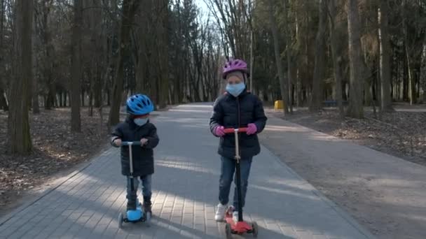 Niño Niña Montan Scooters Con Máscaras Médicas Parque Concepto Protección — Vídeos de Stock