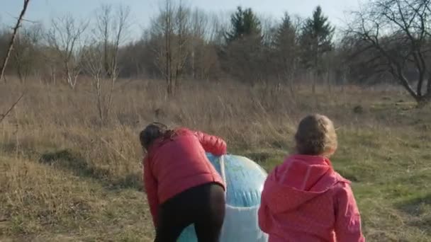 2人の小さな女の子が膨脹可能な球惑星地球にガーゼマスクを置きます コロナウイルス感染に対する保護の概念 Covid — ストック動画