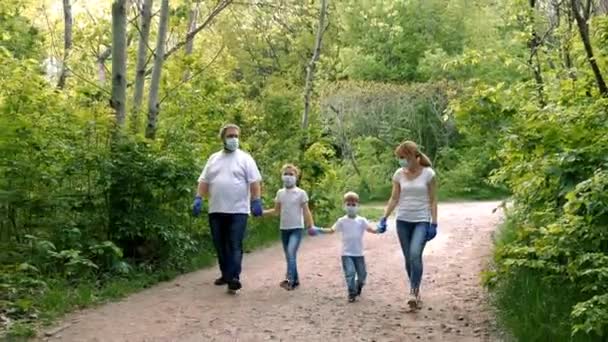 儿子和女儿戴着口罩 白色T恤衫和橡胶手套在公园里散步 Covid Coronavirus感染防护概念 — 图库视频影像