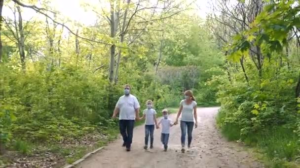 아버지 어머니 의료용 마스크와 티셔츠를 공원을 걷는다 코로나 바이러스 감염으로부터 — 비디오