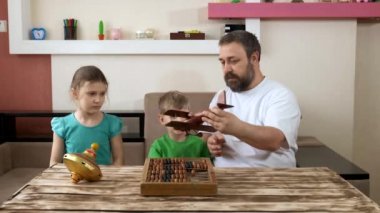 Babam evde tahta bir oyuncak uçakla çocuklarla oynuyor. COVID-19 salgını sırasında karantinada sosyal mesafeler ve kendini izole etme.