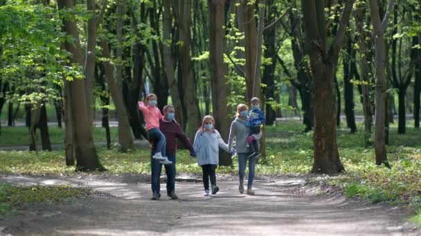 Uma Família Máscaras Médicas Caminha Parque Primavera Pai Mãe Carregam — Vídeo de Stock