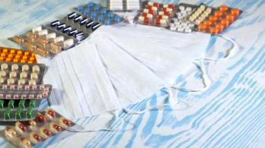 Paketlerdeki beyaz tıbbi maskeler ve haplar sırayla. Tıbbi ilaçlar masada. - Sağlık sigortası ilaçları. COVID-19 'dan uyuşturucu icat etme kavramı