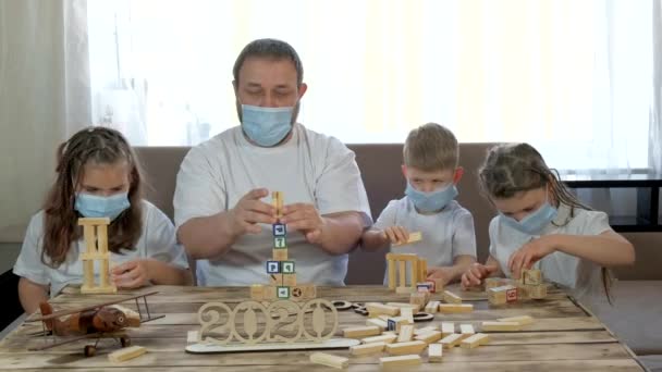 爸爸和孩子们在房间里玩木制玩具和拼图 Covid 19大流行病期间隔离中的社会疏离和自我隔离 — 图库视频影像