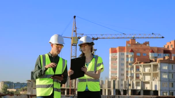 Junge Ingenieure Schutzhelm Und Weste Über Das Projekt Mit Tablet — Stockvideo