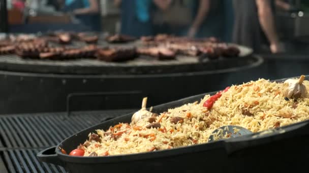 Cauldron Steaming Pilaf Foreground Large Electric Rotating Grill Cooking Ribs — Stock Video