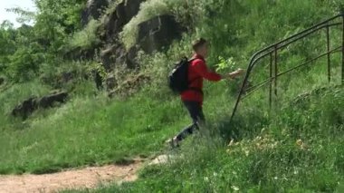 Kırmızı ceketli ve siyah sırt çantalı genç bir adam terk edilmiş yerlere gidiyor. Bir yaz günü, ormandaki eski paslı bir merdivene tırmanır..