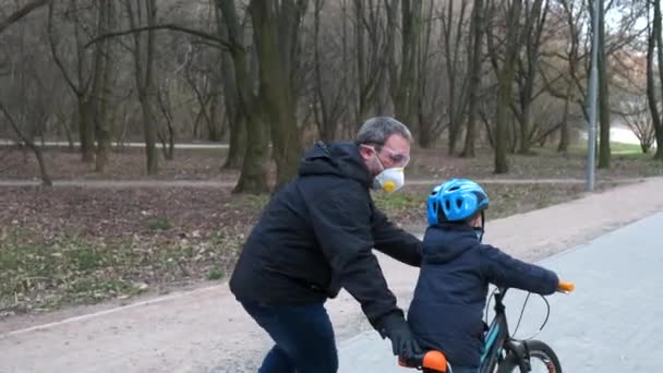 Ojciec Uczy Syna Jeździć Rowerze Parku Miejskim Noszą Kaski Ochronne — Wideo stockowe