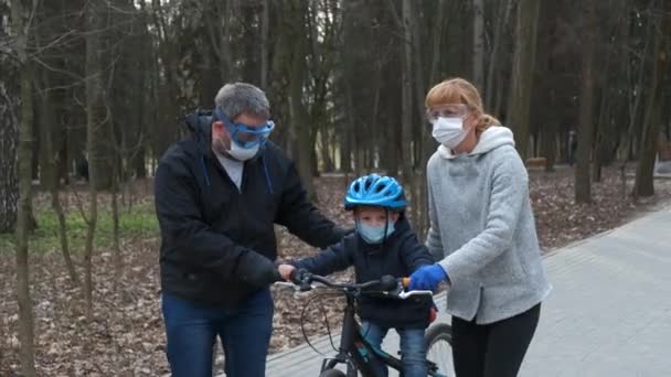 Mamá Papá Enseñan Hijo Andar Bicicleta Parque Ciudad Llevan Cascos — Vídeos de Stock