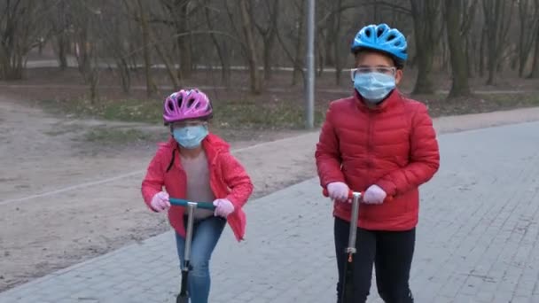 Dos Niñas Hermanas Montan Scooters Con Máscaras Médicas Parque Concepto — Vídeos de Stock