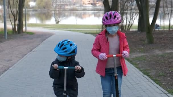 Kleine Jongen Meisje Rijden Scooters Met Medische Maskers Het Park — Stockvideo