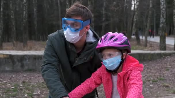 Padre Enseña Hija Montar Bicicleta Parque Ciudad Llevan Cascos Protectores — Vídeos de Stock