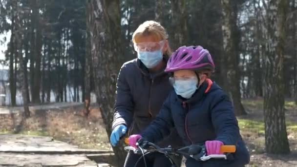 Annem Kızına Şehir Parkında Bisiklet Sürmeyi Öğretiyor Koruyucu Kasklar Tıbbi — Stok video