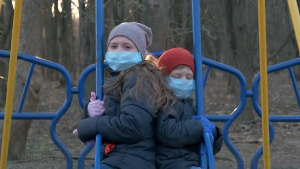Chłopiec Dziewczyna Maskach Medycznych Jeżdżą Huśtawce Koncepcja Ochrony Przed Zakażeniami — Wideo stockowe