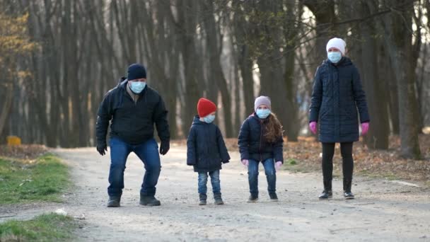 Aile Baba Anne Oğul Kız Baharda Sağlık Maskeleriyle Parkta Yürüyorlar — Stok video