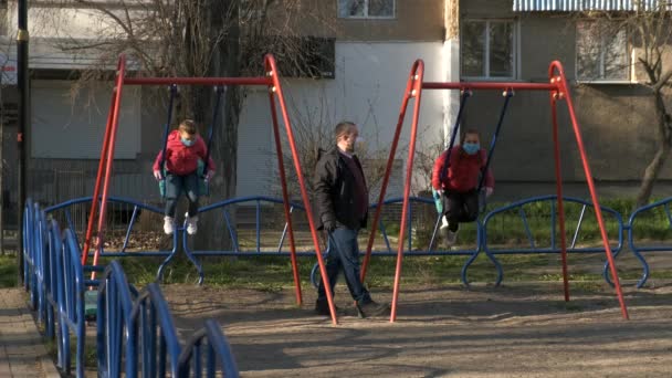 Tata Dwie Córki Maskach Medycznych Placu Zabaw Ojciec Huśta Dzieci — Wideo stockowe