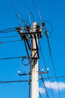 Şehrin arka planında mavi gökyüzü olan eski bir bölümü için eski elektrik hatları.