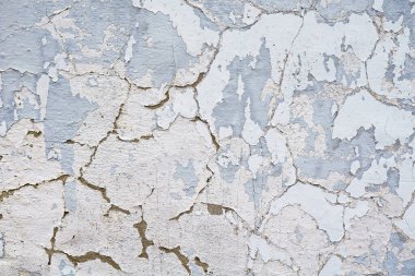 Bir binanın ya da duvarın kenarındaki çatlak ve sıkıntılı boyalı yüzey. Beton ya da çimento desenli ve eski boyası soyulmuş..