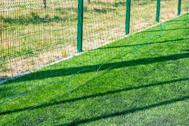 Yeşil koruyucu ızgara yakın plan. Bir spor sahası için koruyucu şebeke deseni. Spor geçmişi.