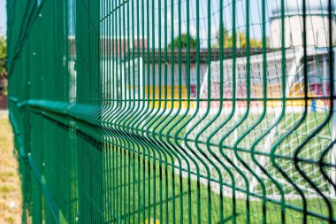 Yeşil koruyucu ızgara yakın plan. Bir spor sahası için koruyucu şebeke deseni. Spor geçmişi.