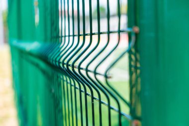 Steel grating fence of soccer field,Metal fence wire with grass in the background. clipart