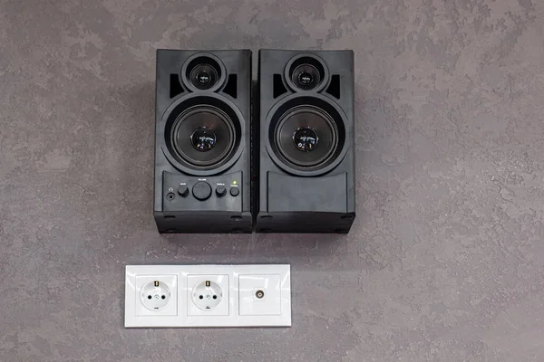 black music speakers hanging on the wall.