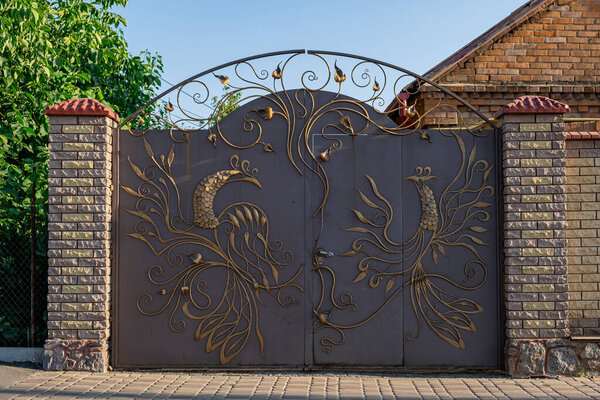 Wrought iron decorative gates are decorated with Golden birds.