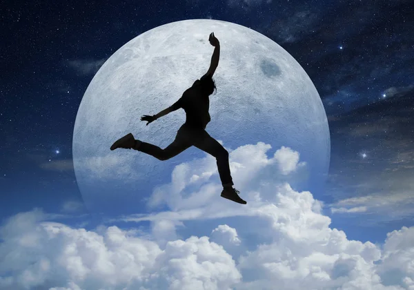 Young man jumping in front a full moon — Stock Photo, Image