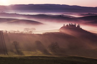 Tuscany Orcia Vadisi'nin sisli tepelerde güneş ışığı