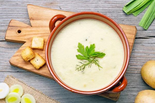 Leek and potato soup on wooden cutting board — Stock Photo, Image