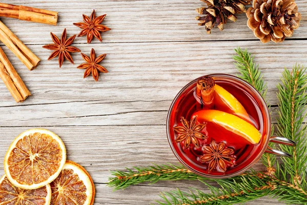 Mulled wine glass and spices on wooden table — Stock Photo, Image