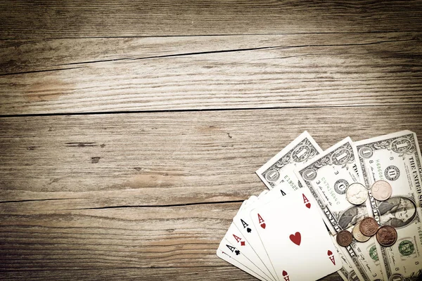 As poker y dinero en efectivo sobre fondo de madera envejecida —  Fotos de Stock