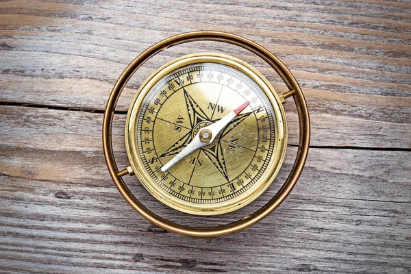 Boussole vintage en laiton isolée sur une table en bois vieilli — Photo