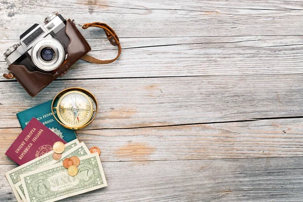 Câmera, bússola, passaportes e dinheiro em fundo de madeira — Fotografia de Stock