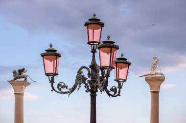 Venedik lamba direği St. Mark 'ın kanatlı aslanı ile İtalya' nın Venedik kentindeki St. Theodore heykelinin sütunları arasında.