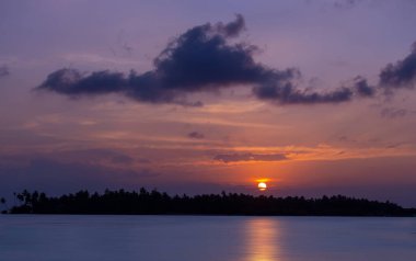 Hint Okyanusu 'ndaki tropik bir adada güzel bir gün batımı
